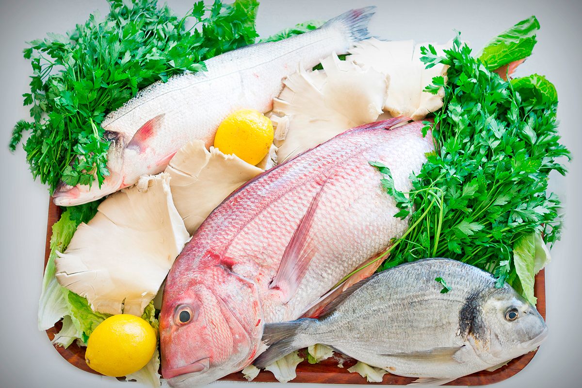 Pescados frescos enteros con perejil y limón