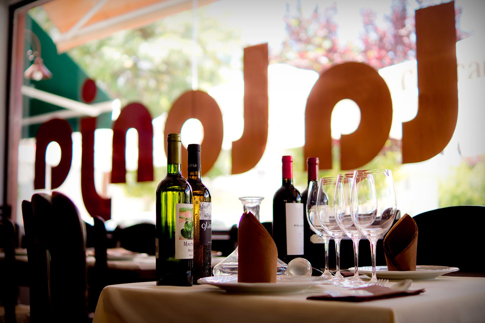 Mesa de La Lonja junto al ventanal con el rótulo del restaurante